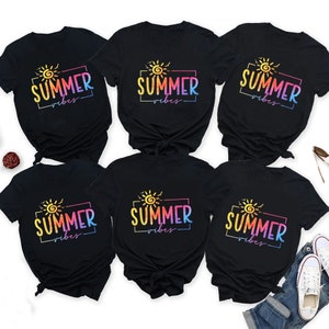 May include: Six black t-shirts with a rainbow sun and the text "Summer Vibes" in a white box.