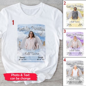 May include: White t-shirt with a photo of a person with angel wings and the text "Rest In Paradise". The text "Add Name", "Sunrise", and "Sunset" are also included. The text "MM-DD-YYYY" is below the words "Sunrise" and "Sunset".