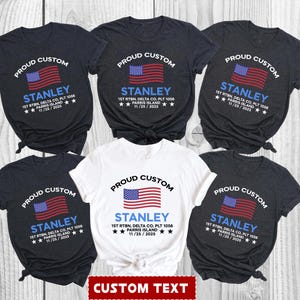 Op de afbeelding: Zes t-shirts met een ontwerp met een Amerikaanse vlag en de tekst "PROUD CUSTOM" erboven. Onder de vlag staat de naam "STANLEY" en andere tekst. De shirts zijn in verschillende kleuren, waaronder zwart en wit, met de tekst "CUSTOM TEXT" onderaan.