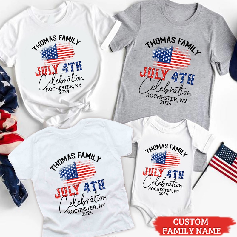 K&ouml;nnte beinhalten: Ein Set aus vier wei&szlig;en T-Shirts mit einem rot-wei&szlig;-blauen amerikanischen Flaggen-Design. Die Shirts tragen den Aufdruck "Thomas Family July 4th Celebration Rochester, NY 2024".