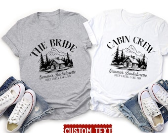 May include: Two gray and white t-shirts with a cabin and forest design. The gray shirt says "The Bride" and the white shirt says "Cabin Crew". Both shirts have the text "Gemma's Bachelorette Deep Creek Lake, MD".