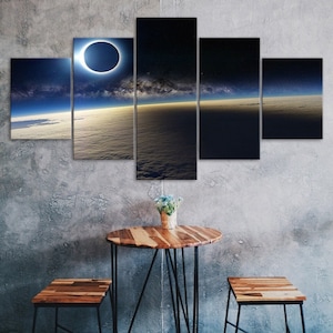 May include: A five-piece canvas print set depicting a solar eclipse over a cloudy sky with a view of Earth's horizon. The eclipse is in the center of the image, with the sun's corona visible around the moon. The sky is a deep blue with stars visible in the background. The clouds are white and fluffy, and the horizon is a light blue.