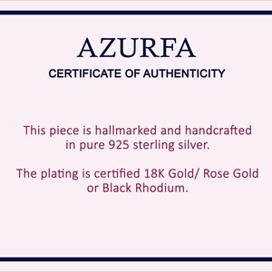 May include: A certificate of authenticity from AZURFA, with a navy blue border. The text states the piece is hallmarked and handcrafted in pure 925 sterling silver. The plating is certified 18K Gold, Rose Gold, or Black Rhodium.