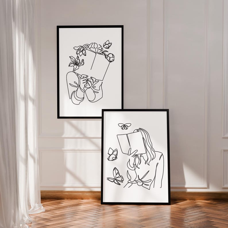 May include: Two framed wall art prints featuring black line art on a white background. The top print shows a figure holding a book with flowers around their head. The bottom print depicts a figure holding a book surrounded by flying butterflies.