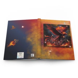 May include: Open journal with a vibrant phoenix illustration on the right page and a fiery bird design on the left. The cover features a gradient of orange, red, and blue hues. The journal has a hardcover.
