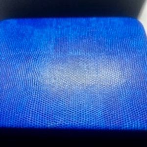 Puede incluir: Una cartera de cuero azul con una superficie texturizada.
