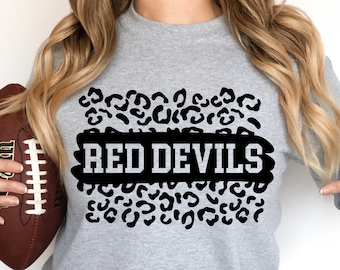 Op de afbeelding: Een grijs sweatshirt met een zwart luipaardprint ontwerp en de tekst "RED DEVILS" in een zwart-witte banner.