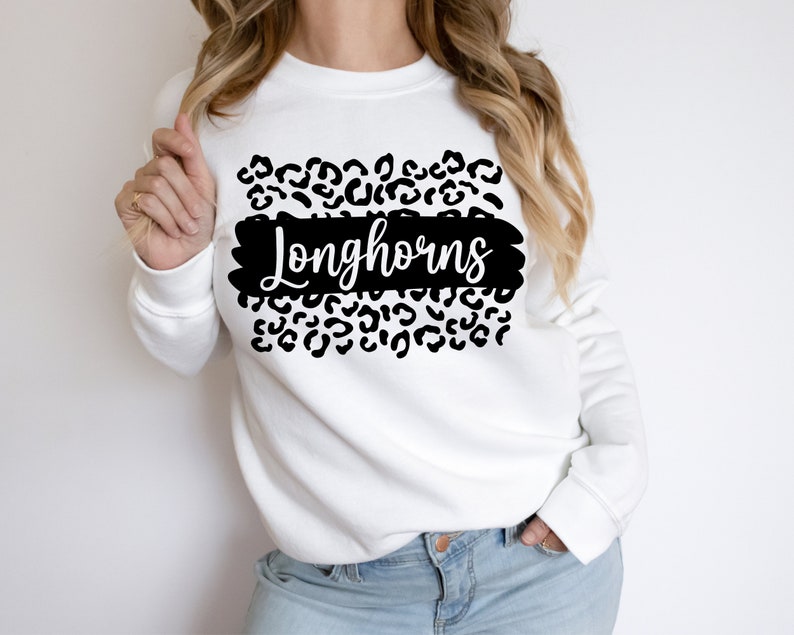 May include: White sweatshirt with a black leopard print design and the word "Longhorns" in black script.
