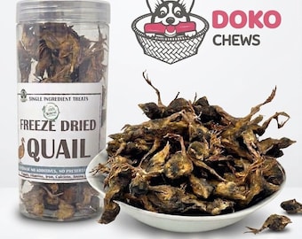 May include: A clear plastic jar and a white bowl filled with freeze-dried quail. The jar has a label that reads "Freeze Dried Quail" and "Single Ingredient Treats." The image also features a cartoon dog with the text "DOKO CHEWS."
