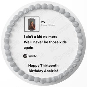 May include: A white cake with gray frosting and a design of a record album with the text "blond" and "Ivy" by Frank Ocean. The cake also has the text "I ain't a kid no more We'll never be those kids again" and "Happy Thirteenth Birthday Anaizia!"