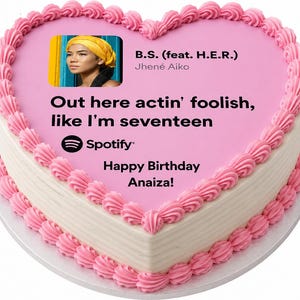May include: A heart-shaped cake with pink frosting and decorative pink frosting around the edges. The cake has a pink top with text and an image of a woman. The text says "B.S. (feat. H.E.R.) Jhené Aiko" and "Out here actin' foolish, like I'm seventeen".