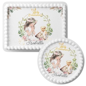 May include: Two white frosted cakes, one rectangular and one round, decorated with a First Holy Communion theme. The cakes feature an illustration of a girl in a white dress, a chalice, a bible, and the name "Isabella".
