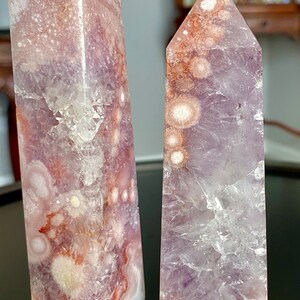 May include: Two amethyst crystal points with white and pink inclusions. The crystal on the left is labeled "A" and the crystal on the right is labeled "B".