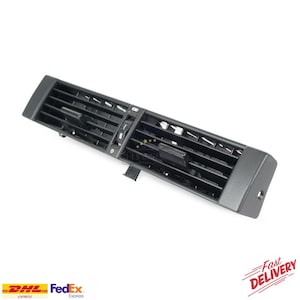 Könnte beinhalten: Eine schwarze Auto-Luftdüse mit verstellbaren Lamellen. Die Düse hat eine rechteckige Form mit einer Reihe horizontaler Lamellen. Das Bild enthält auch die Logos von DHL und FedEx sowie die Worte "Fast Delivery".
