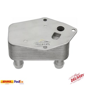 May include: A silver-colored automotive oil cooler with a rectangular cooling core and a top plate with mounting holes. The product has two cylindrical ports and the text "HLS CAR PARTS".