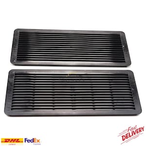 May include: Two black rectangular car vent grilles with horizontal slats. The grilles are made of a matte black material and are set against a white background. The image also includes the logos for DHL, FedEx, and "Fast Delivery".