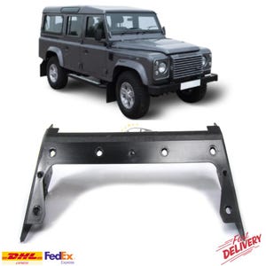 May include: A grey Land Rover Defender SUV is shown above a black automotive part. The part is a bracket with multiple circular holes. The vehicle is a four-door model with silver wheels.