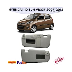 May include: Two grey Hyundai i10 sun visors for a 2007-2012 model year car. The visors have a small rectangular window and a clip on the side.