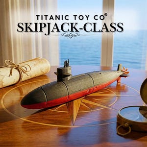 May include: A model submarine with the text "TITANIC TOY CO SKIPJACK-CLASS" is displayed on a wooden table with a compass and a rolled-up map. The submarine is black and red, with a propeller and a conning tower.