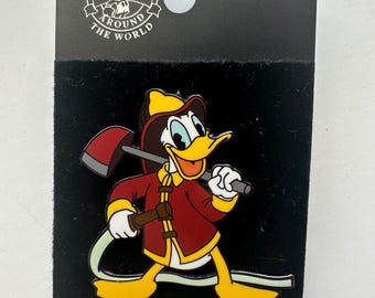 Könnte beinhalten: Ein Disney Pin Trading Pin mit Donald Duck als Feuerwehrmann. Donald trägt eine rote Jacke und gelbe Stiefel und hält eine Axt und einen Schlauch. Der Pin befindet sich auf einem schwarzen Hintergrund mit dem Disney Pin Trading Logo.