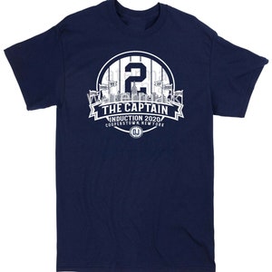 May include: A navy blue t-shirt with a white graphic of a baseball player's number "2" and the text "THE CAPTAIN INDUCTION 2020 COOPERSTOWN, NEW YORK" with a baseball logo.