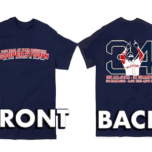 May include: A navy blue t-shirt with red and white text on the front that reads "2022 Hall of Fame Induction Cooperstown". The back of the shirt features a white silhouette of a baseball player wearing a red and white uniform with the number "34" on the back. The text below the player reads "10x All-Star - 3x Champion 541 Home Runs - 2,472 Hits - 1,768 RBIs".