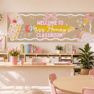 May include: A rectangular classroom banner with a tan background featuring a large yellow pencil graphic, a pink bow, and the text "WELCOME TO Miss Honey's CLASSROOM" in white and pink. The design includes illustrations of notebooks, flowers, and a bag.