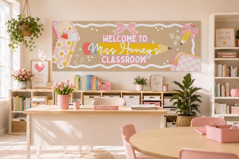 May include: A rectangular classroom banner with a tan background featuring a large yellow pencil graphic, a pink bow, and the text "WELCOME TO Miss Honey's CLASSROOM" in white and pink. The design includes illustrations of notebooks, flowers, and a bag.