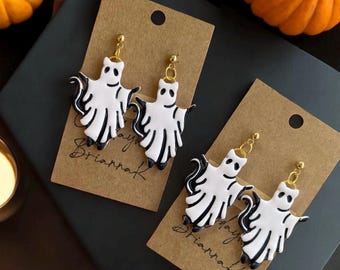 May include: Two pairs of white ghost-shaped earrings with black details on brown card stock with the text "Happy Briarrak" on each card.