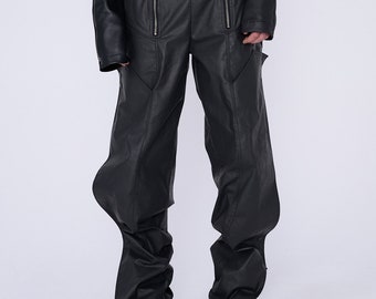 Op de afbeelding: Zwarte leren broek met een uniek, geplooid ontwerp aan de enkels. De broek heeft een ritsdetail aan de voorkant en een ontspannen pasvorm.