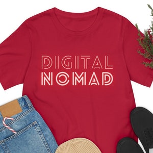 Op de afbeelding: Rood T-shirt met witte tekst die "DIGITAL NOMAD" luidt in een vetgedrukt, omlijnd lettertype.