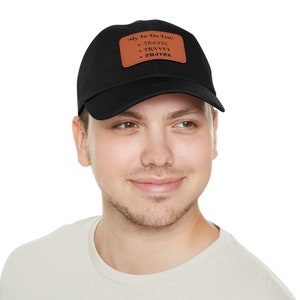 May include: A black baseball cap with a brown leather patch that says "My to-do list: TRAVEL TRAVEL TRAVEL".