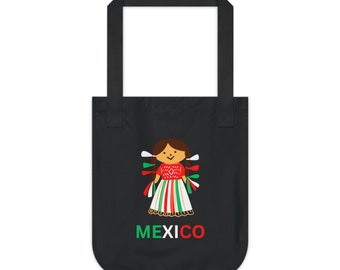Op de afbeelding: Zwarte tote bag met een kleurrijke illustratie van een Mexicaanse pop en het woord "MEXICO" in groen, wit en rood.