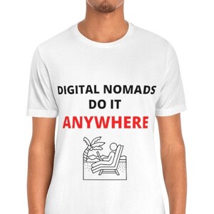 May include: White t-shirt with black text that reads "DIGITAL NOMADS DO IT ANYWHERE" and a black and white illustration of a person sitting on a beach chair with a laptop.