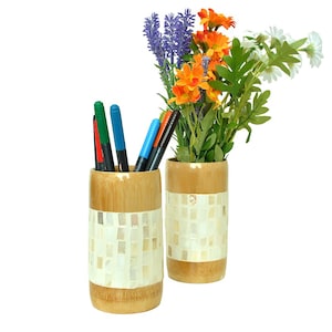 Könnte beinhalten: Zwei Bambus-Bleistifthalter mit einem weißen Mosaikdesign. Der Halter links enthält mehrere bunte Stifte. Der Halter rechts enthält einen Strauß mit Lavendel-, Orangen- und weißen Blumen.