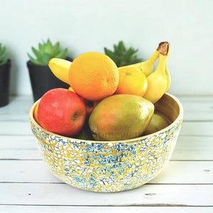 Tigela decorativa artesanal de bambu, formato redondo, decorada com casca de ovo e mosaico azul e dourado.