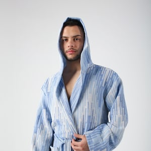 May include: A blue and white patterned hooded robe with a sash tie. The robe has a geometric design with vertical stripes.