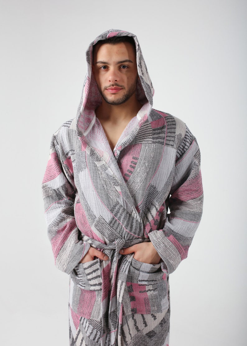 May include: A hooded bathrobe with a geometric pattern in shades of pink, gray, and white.