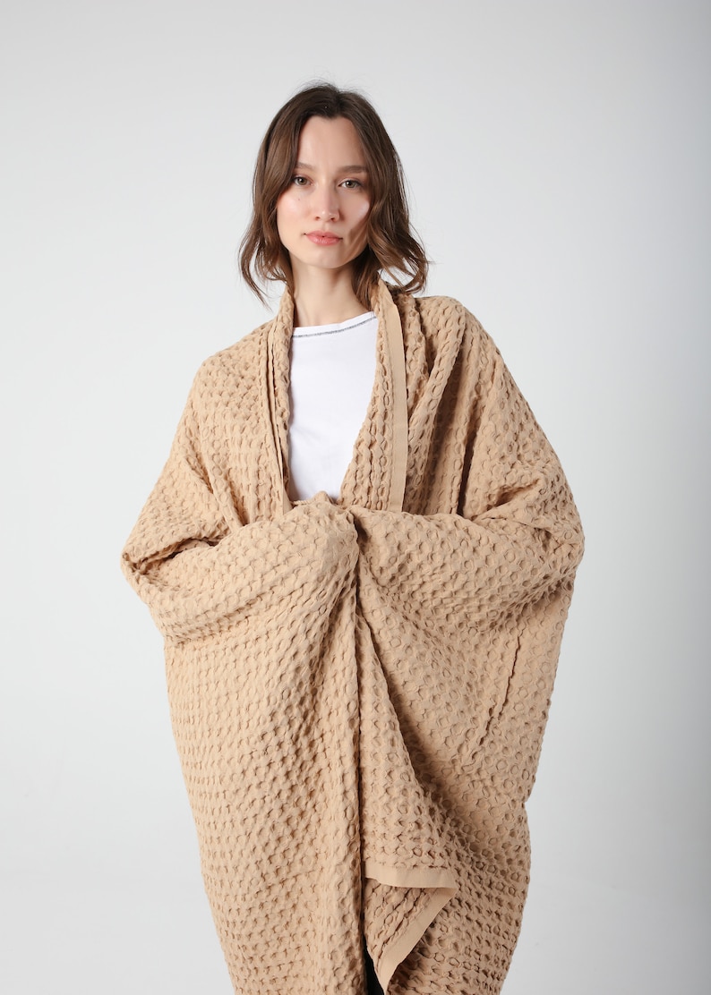 May include: A waffle-weave cardigan in a light brown color. The cardigan is open in the front and has a relaxed fit.