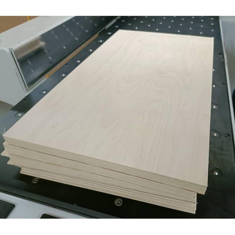 May include: A stack of thin, light wood panels, probably plywood, with a smooth, light-coloured surface. The wood has a subtle grain pattern.