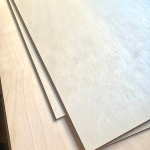May include: Stack of four unfinished, light wood plywood sheets.