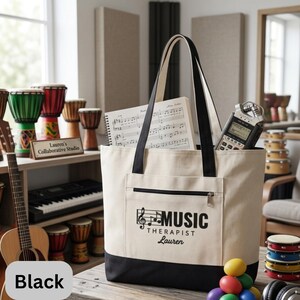 May include: A beige tote bag with black accents, featuring the text "MUSIC THERAPIST Lauren" in black. The bag contains sheet music and a digital recorder. Other musical instruments are visible in the background.