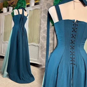 Puede incluir: Un vestido de fiesta de color verde azulado con un corpi&ntilde;o estilo cors&eacute; y una falda fluida. El vestido presenta una espalda con cordones y tirantes finos. Se ve una tela verde azulado m&aacute;s clara debajo de la falda. El vestido tiene cuello halter y lazos largos y fluidos.