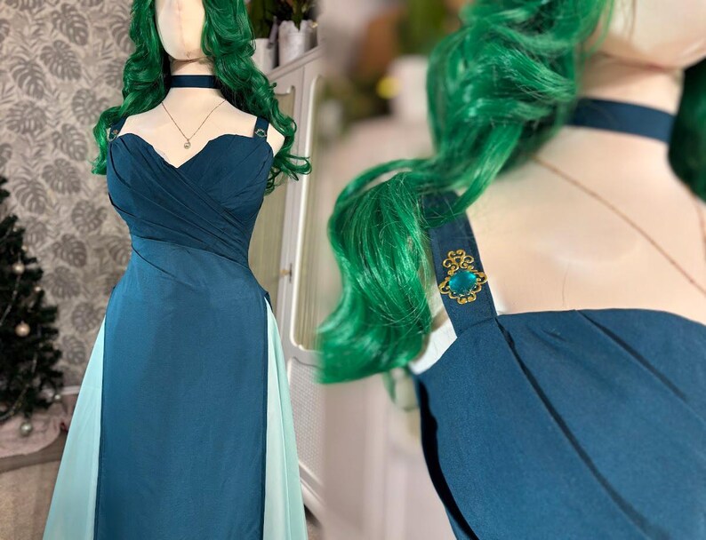 Puede incluir: Un vestido de fiesta color turquesa con escote coraz&oacute;n y falda fluida. El vestido presenta un corpi&ntilde;o drapeado y delicados adornos dorados en los tirantes. Un choker y un collar con colgante a juego completan el look. El vestido se exhibe en un maniqu&iacute;.