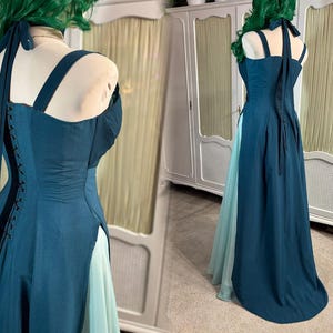 Puede incluir: Un vestido formal de color verde azulado con cuello halter y espalda estilo cors&eacute;. El vestido presenta una falda dividida que revela una capa inferior azul claro. El corpi&ntilde;o tiene un dise&ntilde;o estructurado y el vestido se exhibe en un maniqu&iacute;.