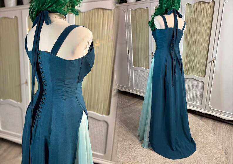 Puede incluir: Un vestido formal de color verde azulado con cuello halter y espalda estilo cors&eacute;. El vestido presenta una falda dividida que revela una capa inferior azul claro. El corpi&ntilde;o tiene un dise&ntilde;o estructurado y el vestido se exhibe en un maniqu&iacute;.