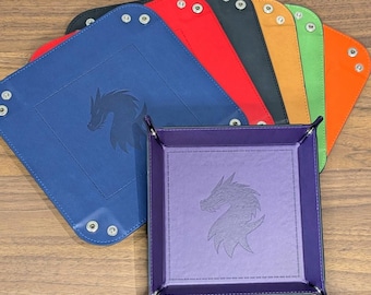 May include: A collection of square valet trays in various colors including purple, blue, red, black, orange, yellow, and green. Each tray features a debossed dragon silhouette in the center and metal snap buttons at the corners for assembly.
