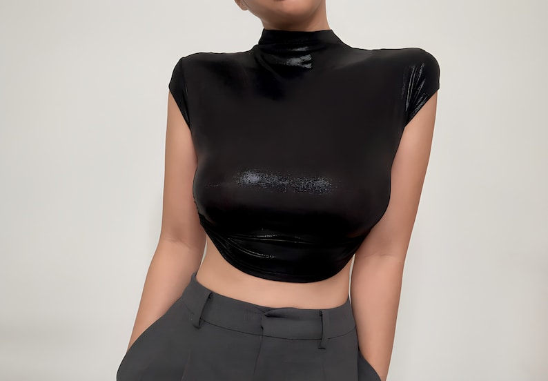 May include: A black mock neck shirt with short sleeves and a shiny finish. The shirt is cropped and has a fitted silhouette.