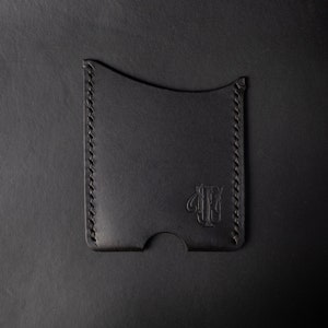Cartera minimalista en vertical hecha en cuero Buttero en negro, cosida a mano con hilo negro. The Lone Wolf.