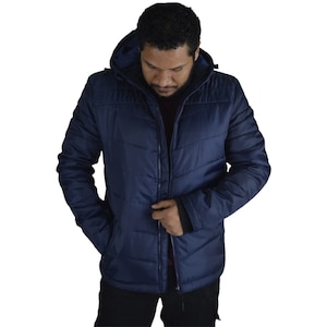 Könnte beinhalten: Eine marineblaue Steppjacke mit Kapuze und Reißverschluss. Die Jacke hat ein gestepptes Design und zwei Fronttaschen.